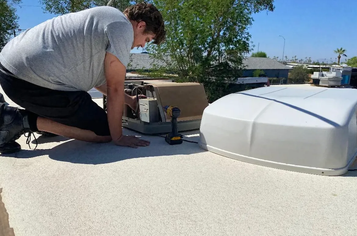 A technician servicing a rooftop air conditioner on an RV in Sebastian, Florida